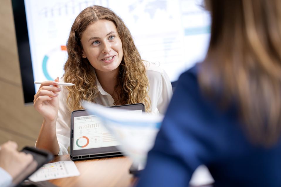 Use Data-Driven Decision-Making to Fuel Business Growth. Business Development Teams explain or make strategies from business insight data to drive business plan objectives forward over a tablet computer in a business office.