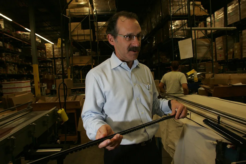 An archived Herald News photo showing Stephan A. Roth, Executive Vice President of Spiral Binding Company, Inc. in Totowa holding a plastic comb, or binder, approximately four feet long. The company was celebrating their 75th anniversary that year.