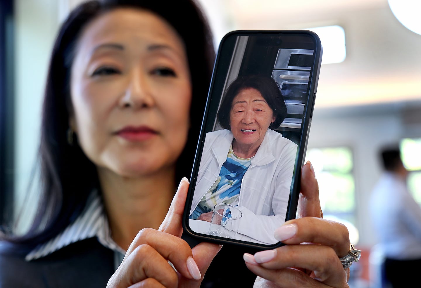 Grace Lee took a new job as CEO of St. Mary’s Credit Union in part to have more time to be there for her 91-year-old mother in Los Angeles, pictured on her phone.
