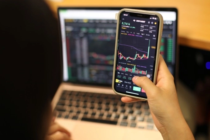 A Vietnamese investor tracking crypto price movements on a smartphone. Photo by VnExpress/Khuong Nha